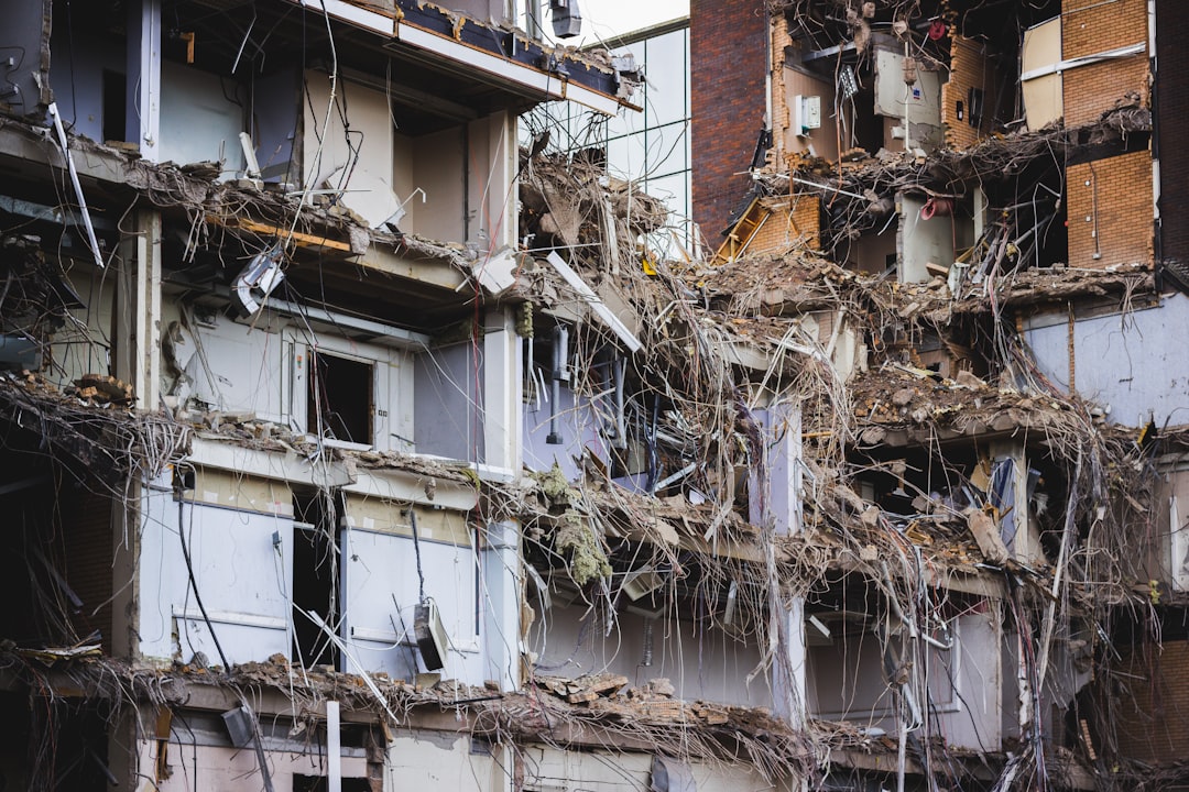 The facade of an office block removed to expose office spaces, cables, rooms and the structure.